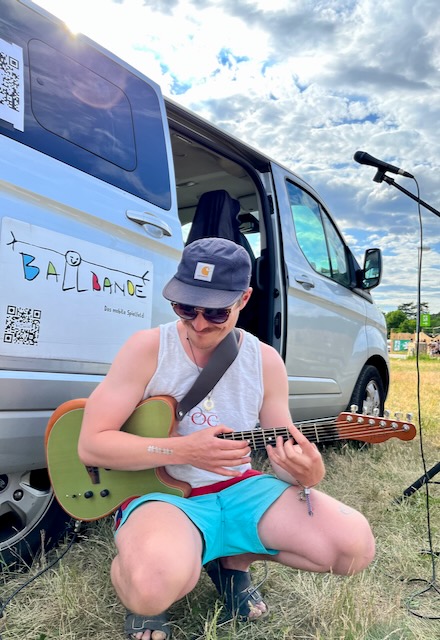 Ein Festival Gast spielt Gitarre 